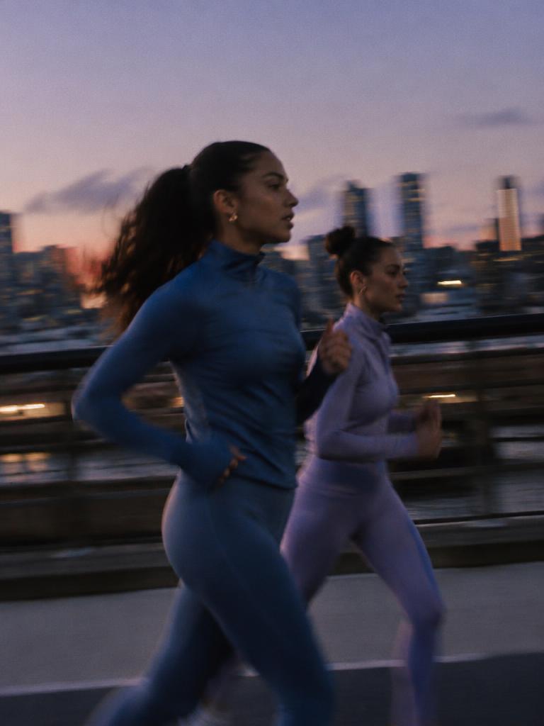 Two women running outdoors at dusk